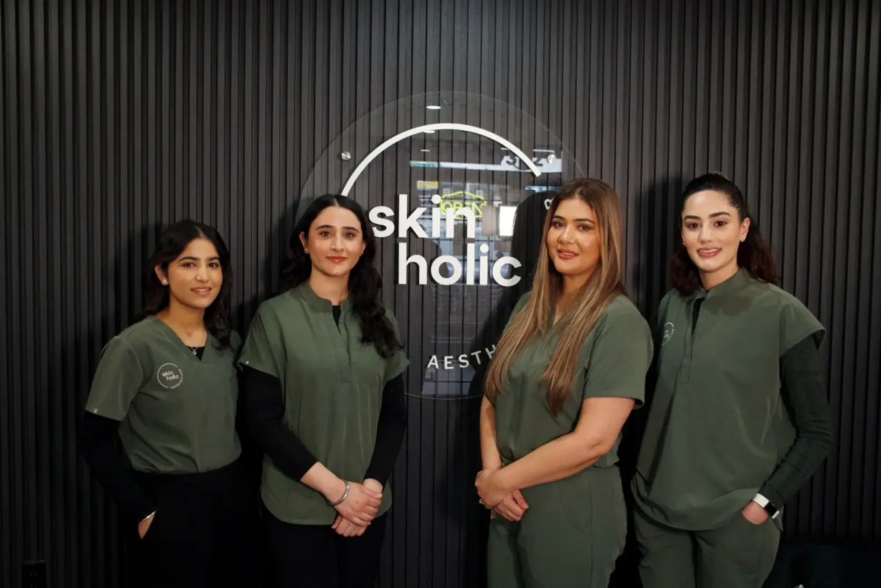 Members of the Skinholic team in front of the clinic sign.