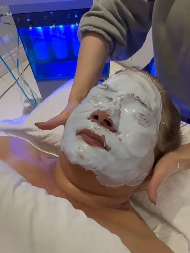 A client relaxing in a facial mask