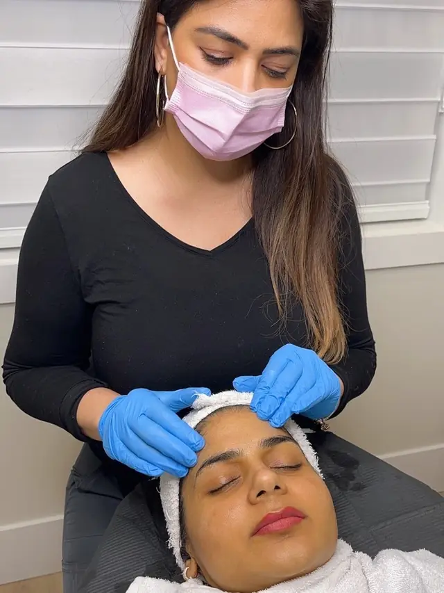 A practitioner applying skincare during a facial
