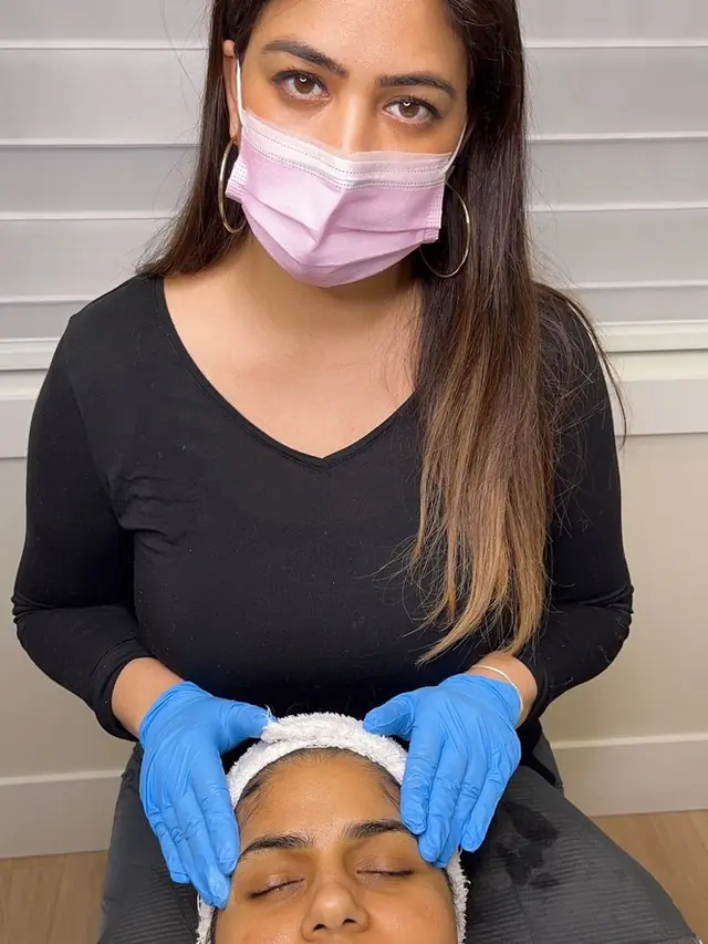 A medical aesthetician preparing a client for a facial