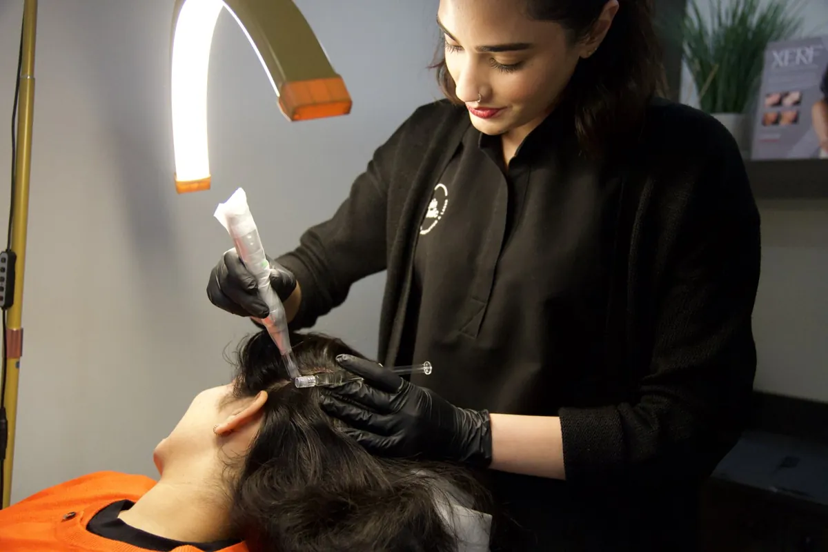 A Skinholic practitioner performing a scalp treatment